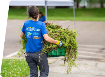 Goodyear associate volunteering outside carrying plant box