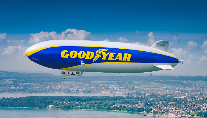 Goodyear Blimp flying over a large body of water and land