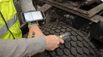 person using tire optix tool on a tire to measure tread depth