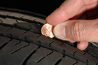 Consumers can regularly check the remaining tread depth of their tires with this simple test. Place a penny in the tread with Lincoln's head upside down and facing you. If you can see the top of Lincoln's head, it is time to replace your tires. This tire shows low tread depth and a probable need for replacement.